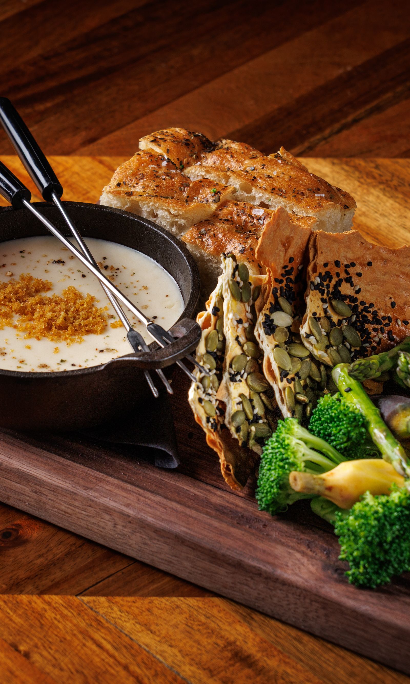 A board of toast and roasted vegetables with a glass of red wine
